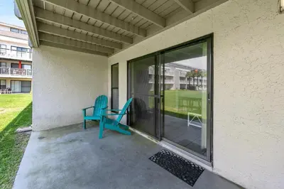 a blue chair sitting on a porch next to a window at Endless Summer B4 in Panama City Beach