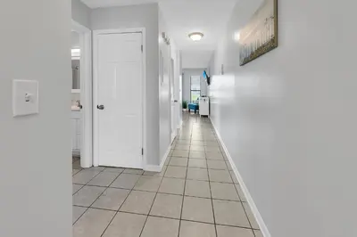 a hallway with white walls and a tile floor at Endless Summer B4 in Panama City Beach