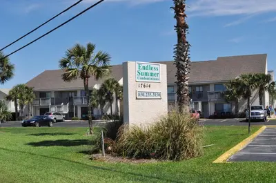 a sign in front of a building with a palm tree at Endless Summer B4 in Panama City Beach