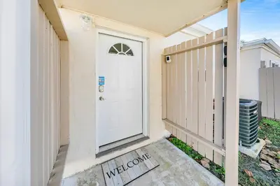 a white door on a house with a fence at Horizon South 11C1 in Panama City Beach