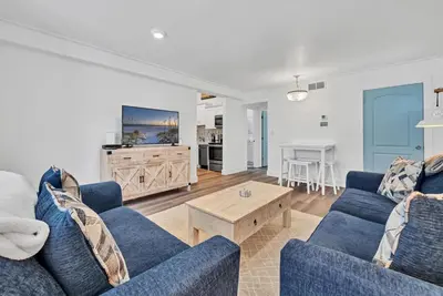 a living room with two blue couches and a table at Horizon South 11C1 in Panama City Beach