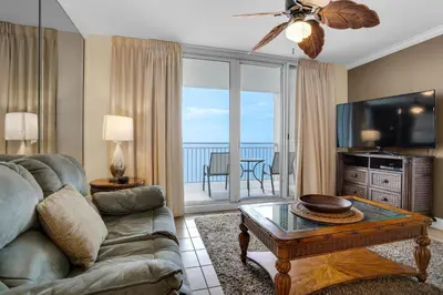 a living room with a couch and a flat screen tv at Emerald Beach 930 in Panama City Beach