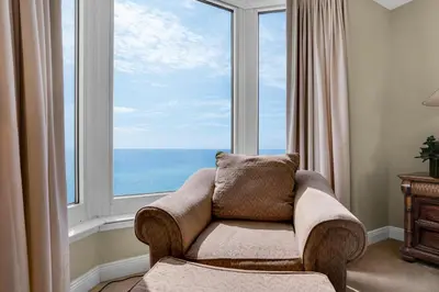 a living room with a couch and a large window at Emerald Beach 930 in Panama City Beach