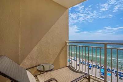 a balcony with a chair and a view of the beach at Emerald Beach 930 in Panama City Beach