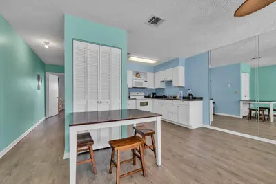 a kitchen with blue walls and a table and chairs at Southwind C-3 in Panama City Beach