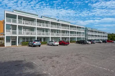 a large white building with cars parked in a parking lot at Southwind C-3 in Panama City Beach