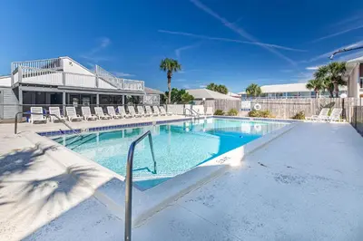 a swimming pool with chairs and a building at Southwind C-3 in Panama City Beach