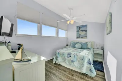 a bedroom with a bed and a desk and a window at Nautical Watch 14 B in Panama City Beach