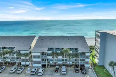 an aerial view of a building with a parking lot and the ocean at Nautical Watch 14 B in Panama City Beach