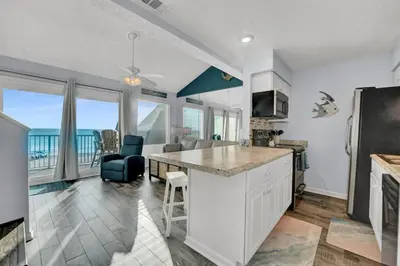 a kitchen and living room with a view of the ocean at Nautical Watch 14 B in Panama City Beach