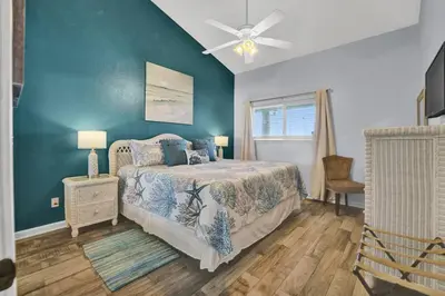 a bedroom with a bed and a blue wall at Nautical Watch 14 B in Panama City Beach
