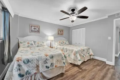 a bedroom with two beds and a ceiling fan at Regency Towers 1121 in Panama City Beach