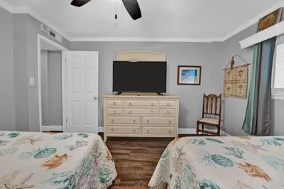 a bedroom with two beds and a flat screen tv at Regency Towers 1121 in Panama City Beach