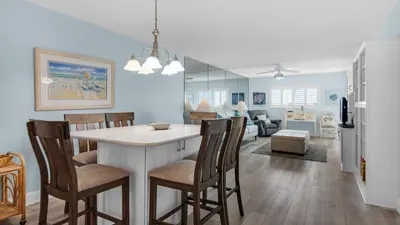 a kitchen and living room with a table and chairs at Regency Towers Unit 725 in Panama City Beach