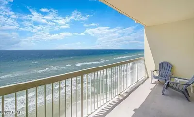 a balcony with two chairs and a view of the ocean at New listing: Gulf/Beach Front Amazing Views in Panama City Beach