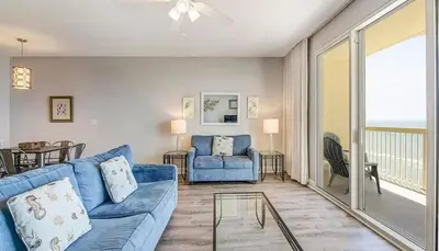 a living room with a blue couch and a glass table at New listing: Gulf/Beach Front Amazing Views in Panama City Beach
