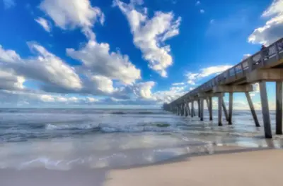 a pier stretches out into the ocean on a beach at New Listing: Water Views, Beach, West end near 30A in Panama City Beach