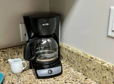 a coffee maker sitting on a counter next to a cup at New Listing: Water Views, Beach, West end near 30A in Panama City Beach
