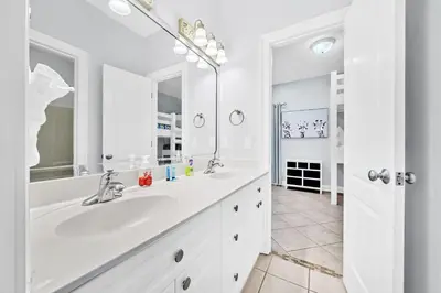 a white bathroom with a sink and a mirror at 3 Generations Beach House in Watersound Beach