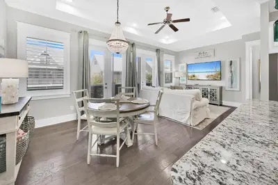 a dining room and living room with a table and chairs at Town of Prominence 67C - Pour Beach Life in Inlet Beach