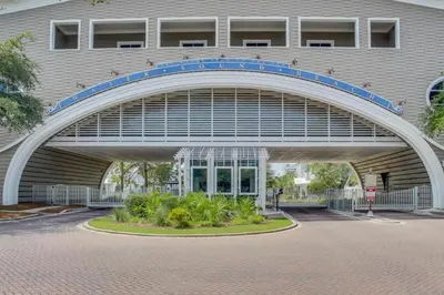 a building with an archway in front of a building at Almost Heaven in Watersound Proper INCLUDES Carriage House! Bedding for 12 in Rosemary Beach