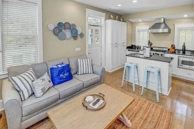 a living room with a couch and a kitchen at Almost Heaven in Watersound Proper INCLUDES Carriage House! Bedding for 12 in Rosemary Beach