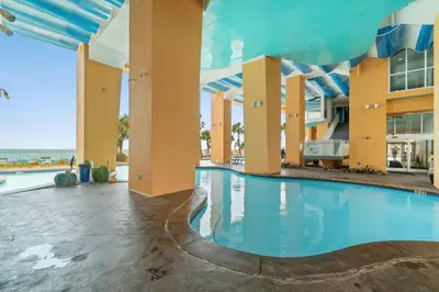 a pool at a resort with the ocean in the background at Splash Resort Beachfront in Panama City Beach