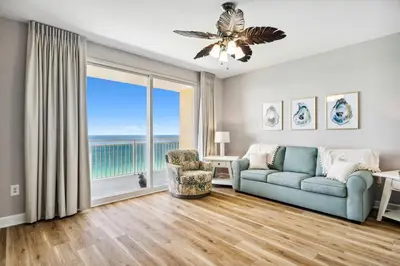 a living room with a couch and a large window at Splash Resort Beachfront in Panama City Beach