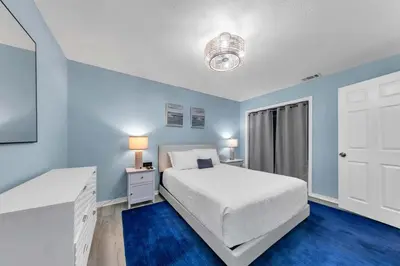 a bedroom with a white bed and blue walls at Gulf Highlands 108 in Panama City Beach