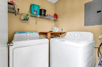 a laundry room with two washers and a table at Gulf Highlands 108 in Panama City Beach
