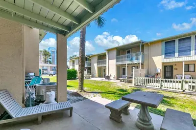 a patio with a table and chairs and a picnic table at Gulf Highlands 108 in Panama City Beach