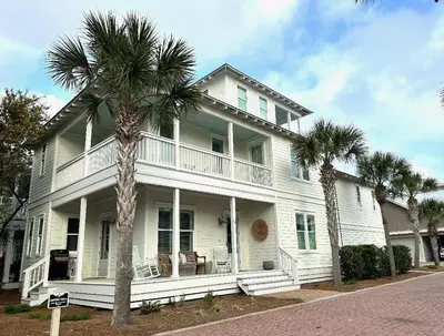 a white house with palm trees in front of it at Moonlight and Starlight Escape in Panama City Beach