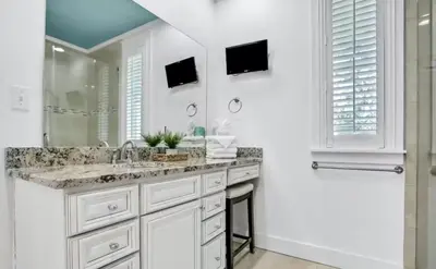 a white bathroom with a sink and a mirror at Moonlight and Starlight Escape in Panama City Beach
