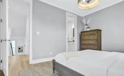 a white bedroom with a bed and a mirror at Moonlight and Starlight Escape in Panama City Beach
