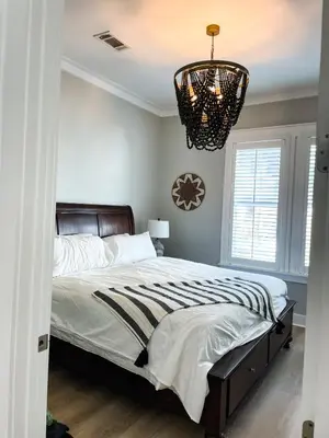 a bedroom with a large bed with a chandelier at Moonlight and Starlight Escape in Panama City Beach