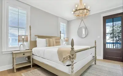 a bedroom with a large bed and a chandelier at Moonlight and Starlight Escape in Panama City Beach
