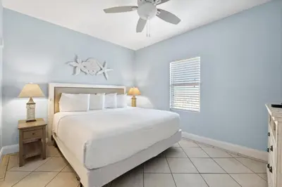 a bedroom with a white bed and a ceiling fan at Laketown Wharf #1404 by Nautical Properties in Panama City Beach