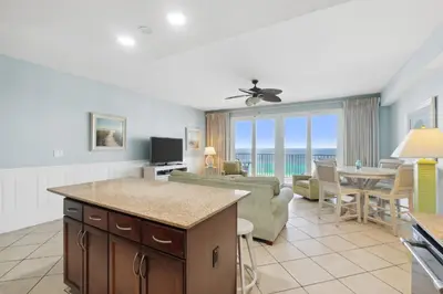 a kitchen and living room with a view of the ocean at Laketown Wharf #1404 by Nautical Properties in Panama City Beach