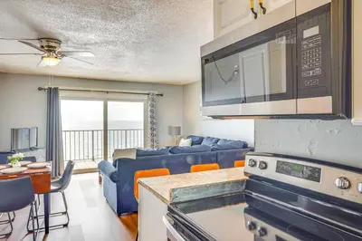 a kitchen and living room with a couch and a table at Steps to Shore PCB Condo with Pool Access and Views! in Panama City Beach