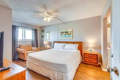 a bedroom with a large white bed and a couch at Steps to Shore PCB Condo with Pool Access and Views! in Panama City Beach
