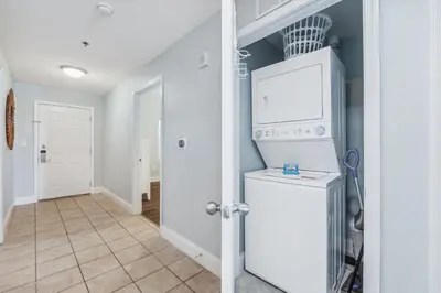 a kitchen with a washer and dryer at Low Floor 3BD plus Bunks Condo! Family Resort! 5 Pools! Free Beach Chair Service! in Panama City Beach