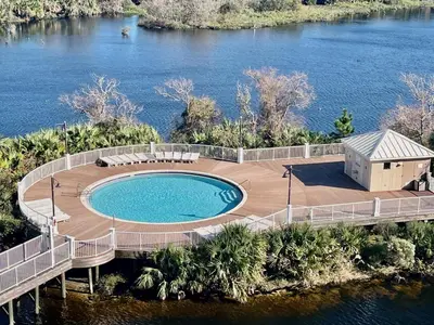 a swimming pool on a deck next to the water at Low Floor 3BD plus Bunks Condo! Family Resort! 5 Pools! Free Beach Chair Service! in Panama City Beach
