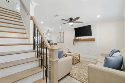 a living room with stairs and a flat screen tv at La Costeñita in Panama City Beach