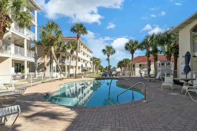 a swimming pool in a courtyard with palm trees at Horizon South 40C- Good Vibes in Panama City Beach