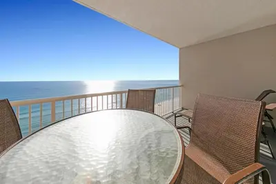 a table and chairs on a balcony with the ocean at Palazzo 404 in Panama City Beach