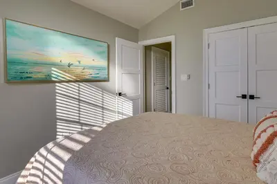 a bedroom with a bed and a painting on the wall at Family-Friendly PCB Vacation Rental, Walk to Beach in Panama City Beach
