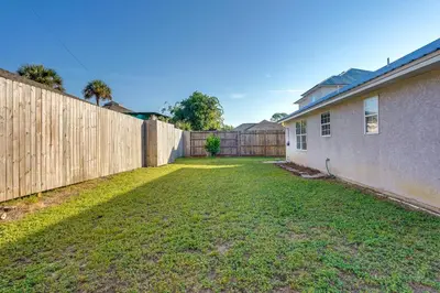 a fence in a yard next to a house at Family-Friendly PCB Vacation Rental, Walk to Beach in Panama City Beach
