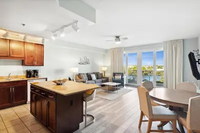 a kitchen and living room with a table and a dining room at Laketown Wharf #302 by Nautical Properties in Panama City Beach