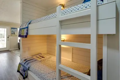 a bunk bed in a room with a bunk bed in a house at Charming PCB Condo with Balcony Walk to Beach! in Panama City Beach