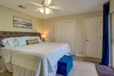 a bedroom with a bed and a ceiling fan at Charming PCB Condo with Balcony Walk to Beach! in Panama City Beach